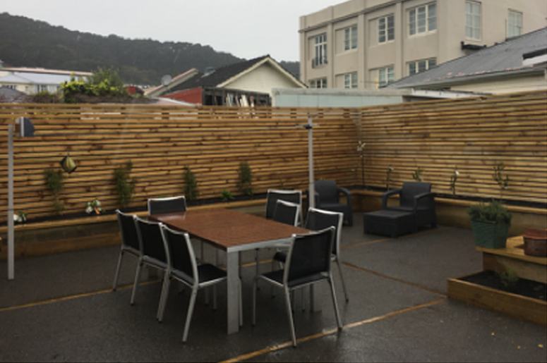 New split-level courtyard with raised gardens and an oriental trellis fence